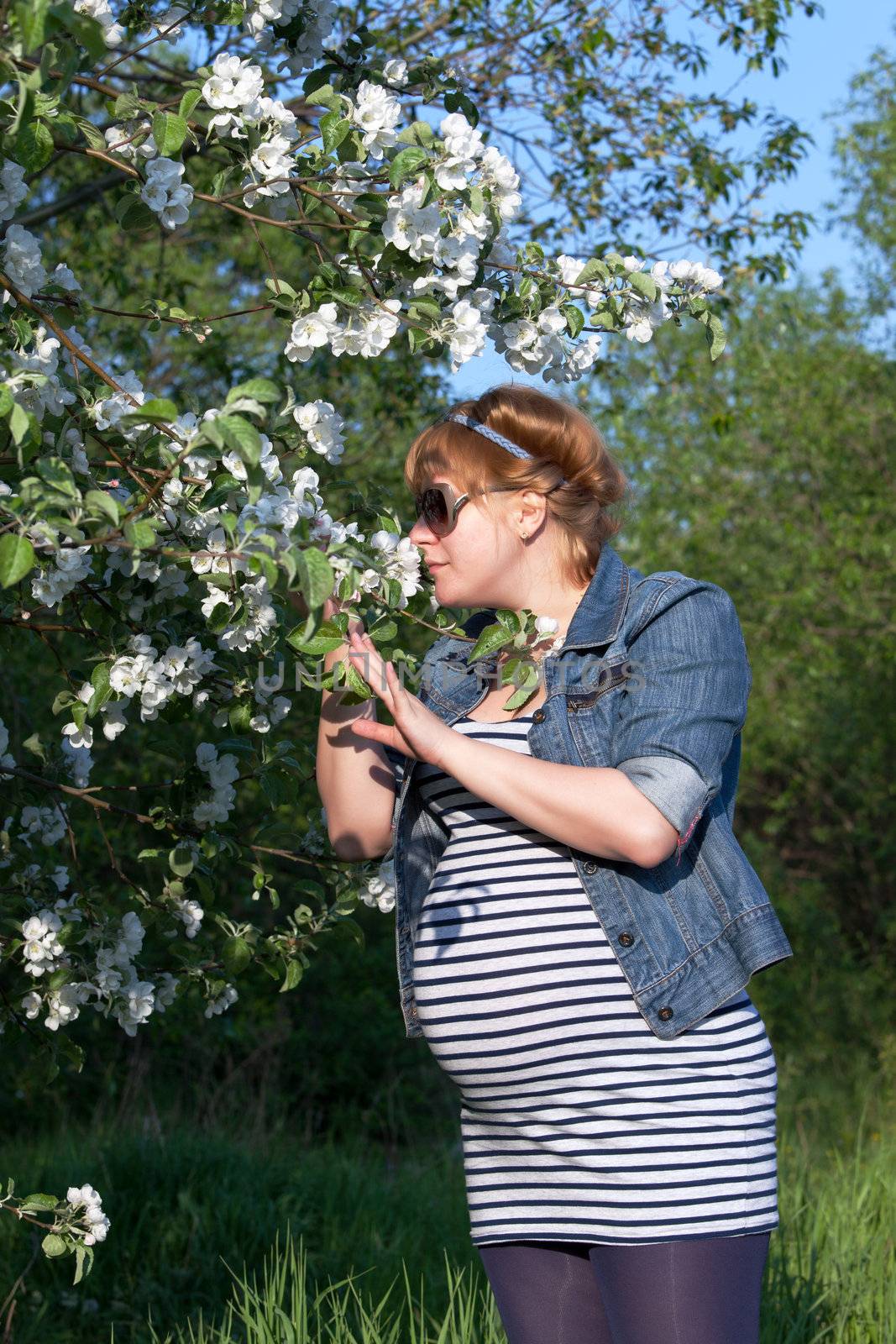 Pregnant woman sniffing flower by Discovod