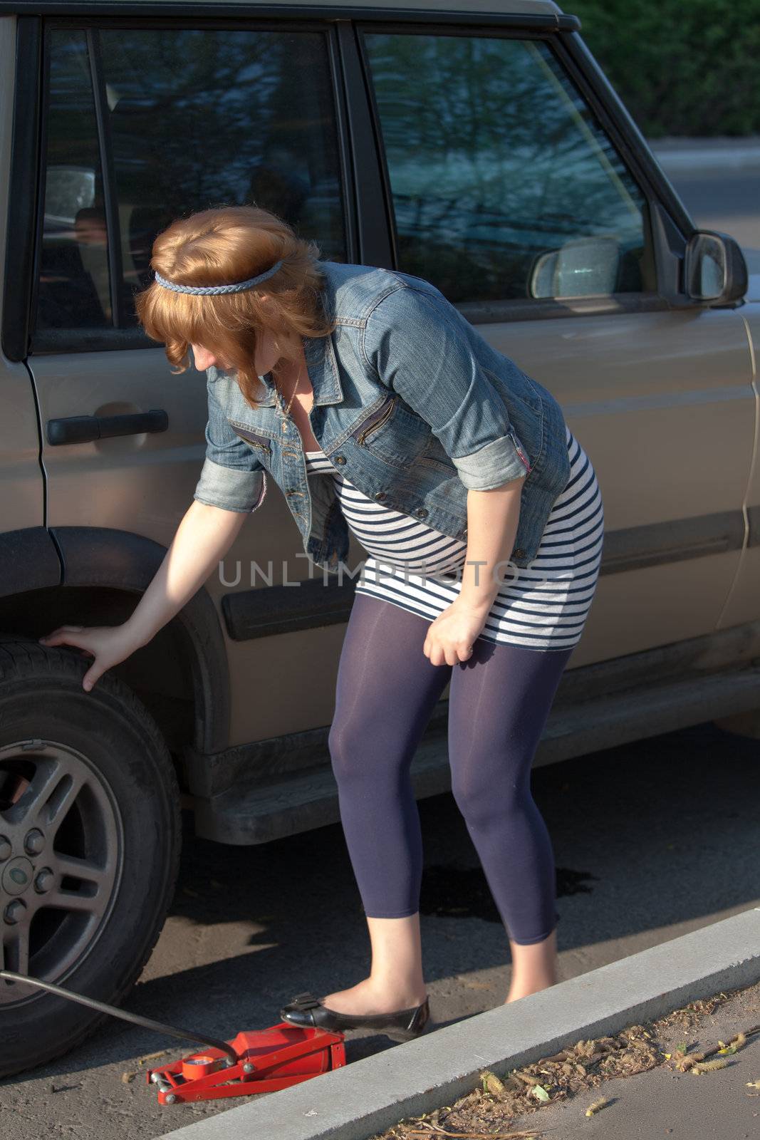 Pregnant woman pumping up the wheel