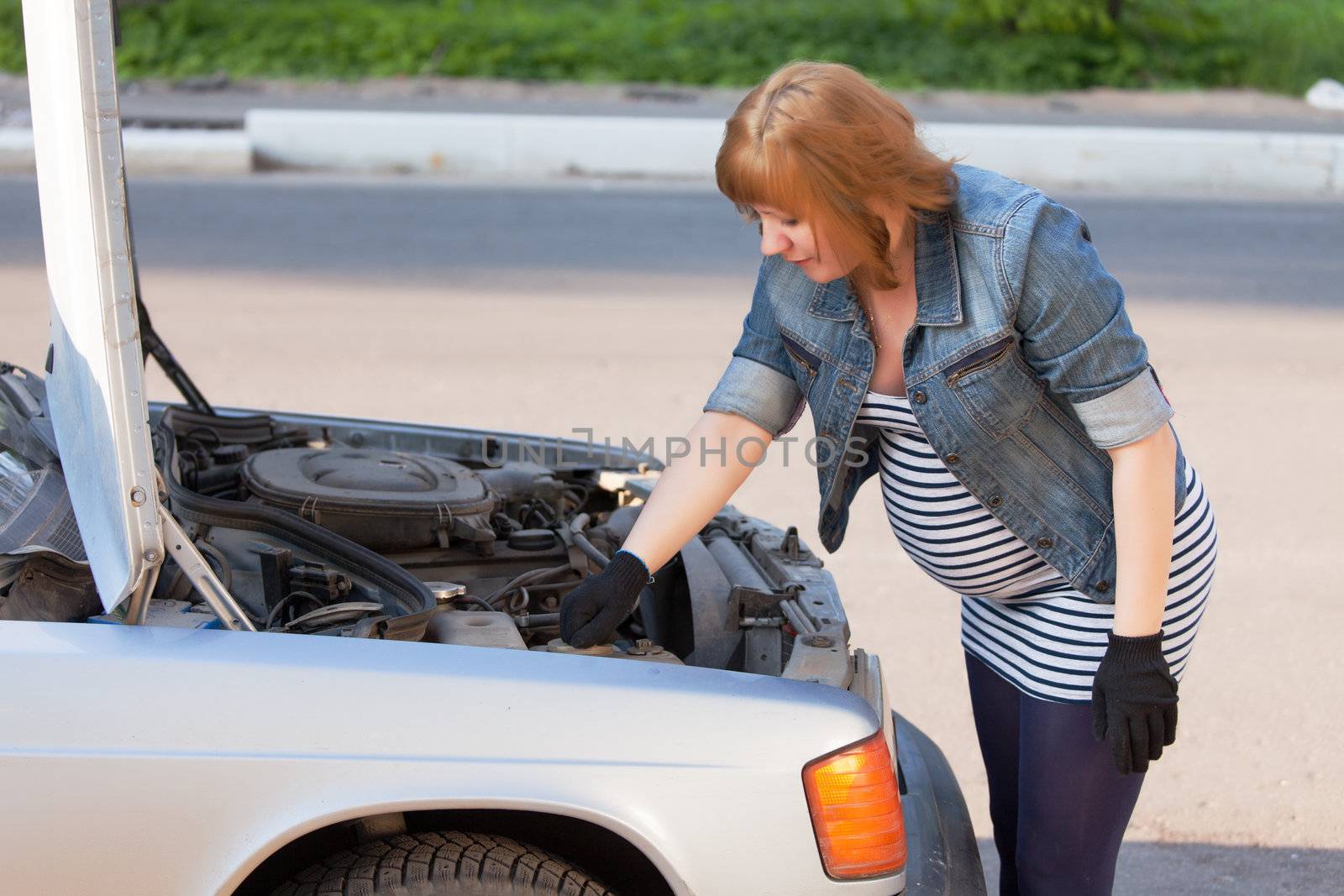 Pregnant Woman Trying to Repair the Car