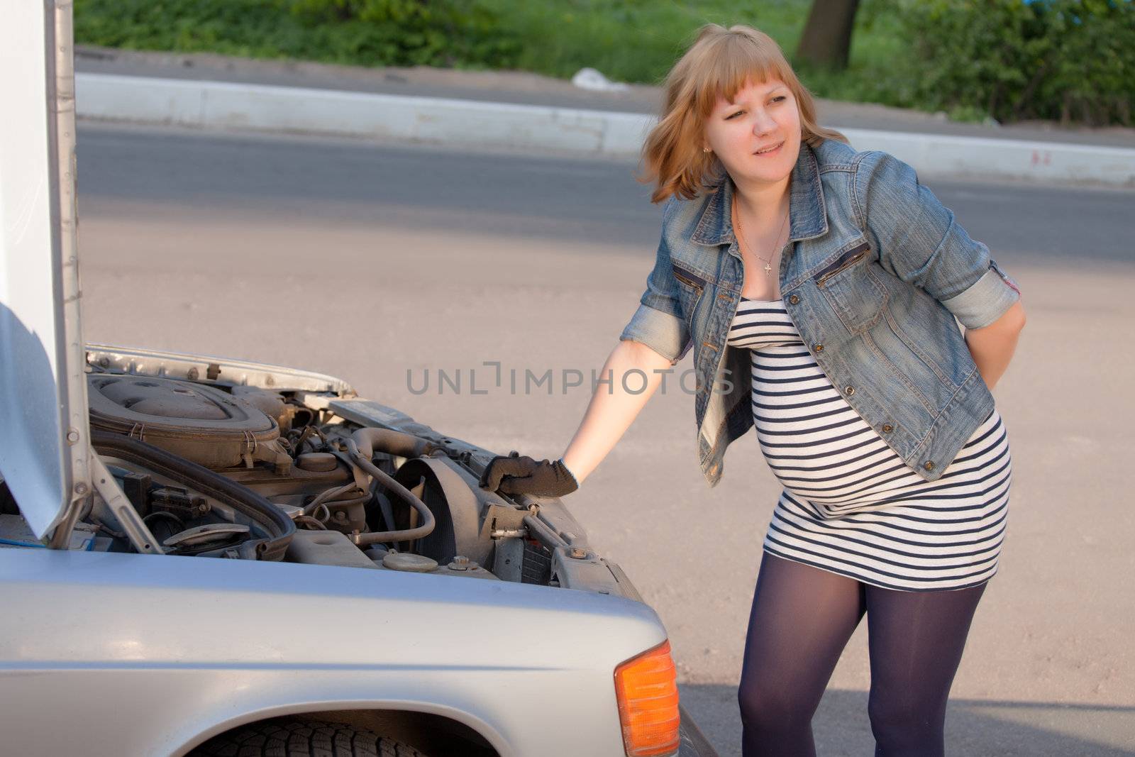 Pregnant Woman Trying to Repair the Car