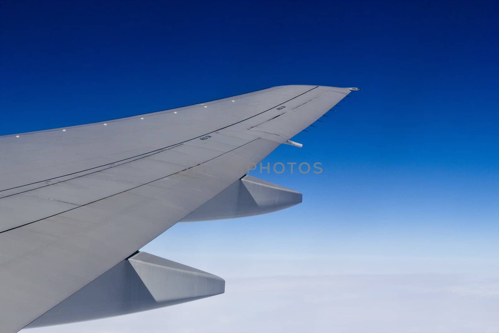 Wing of the plane and the dark blue sky at height of 10000 meters