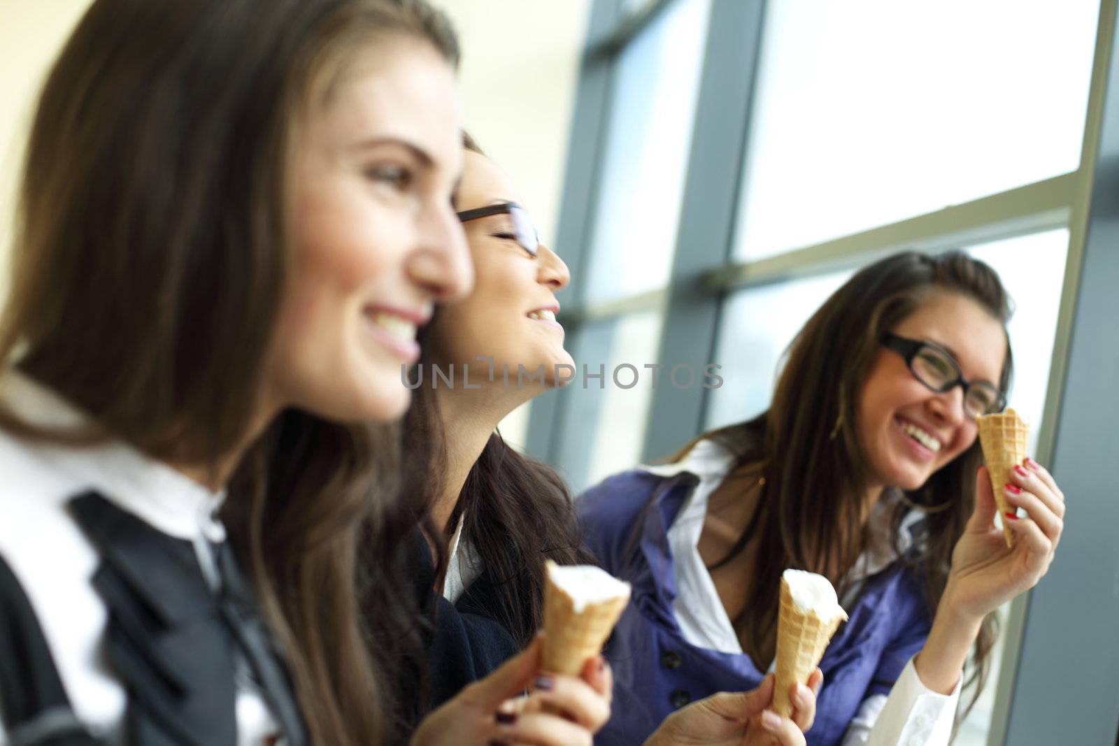 women on foreground licking ice cream 