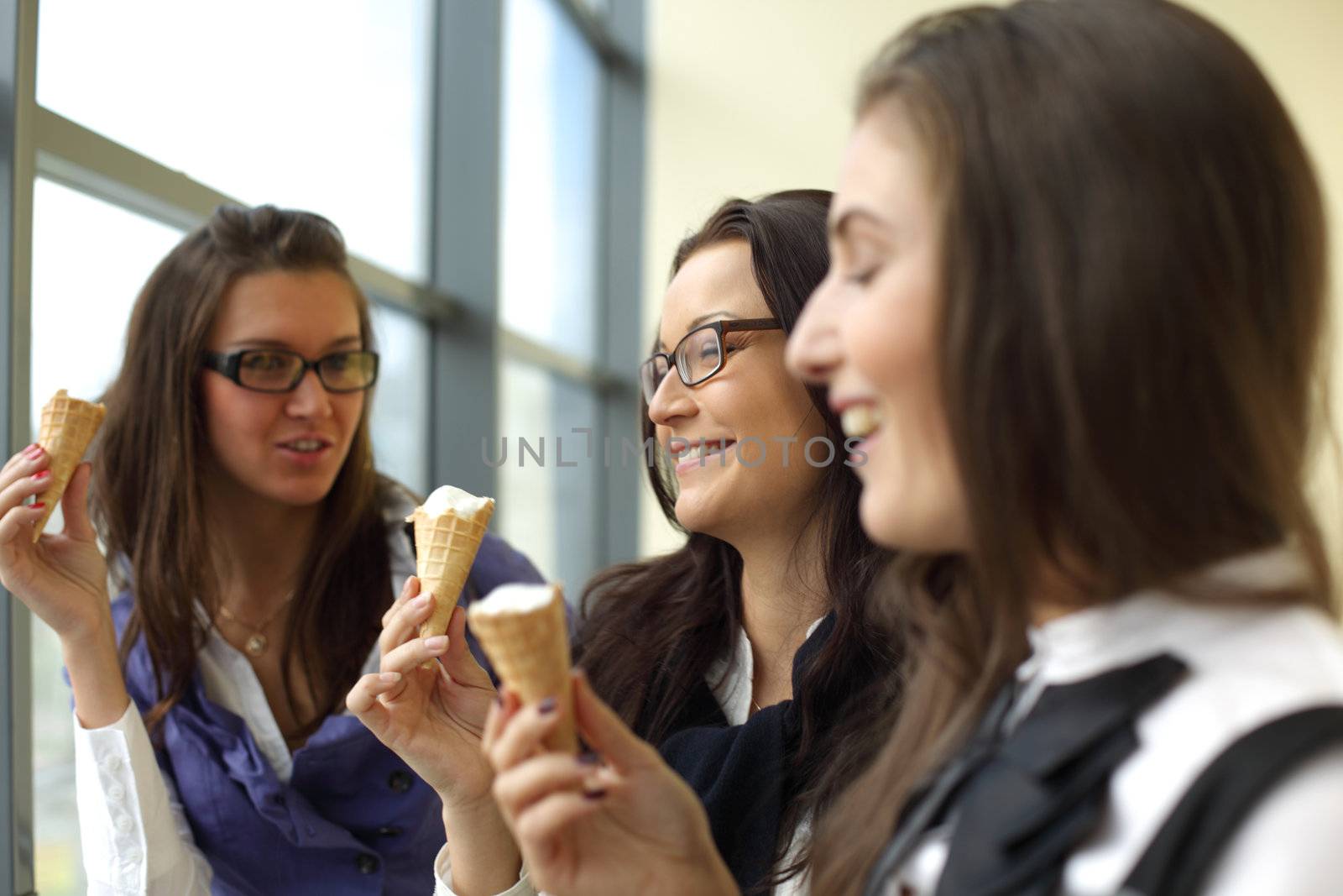 women on foreground licking ice cream 