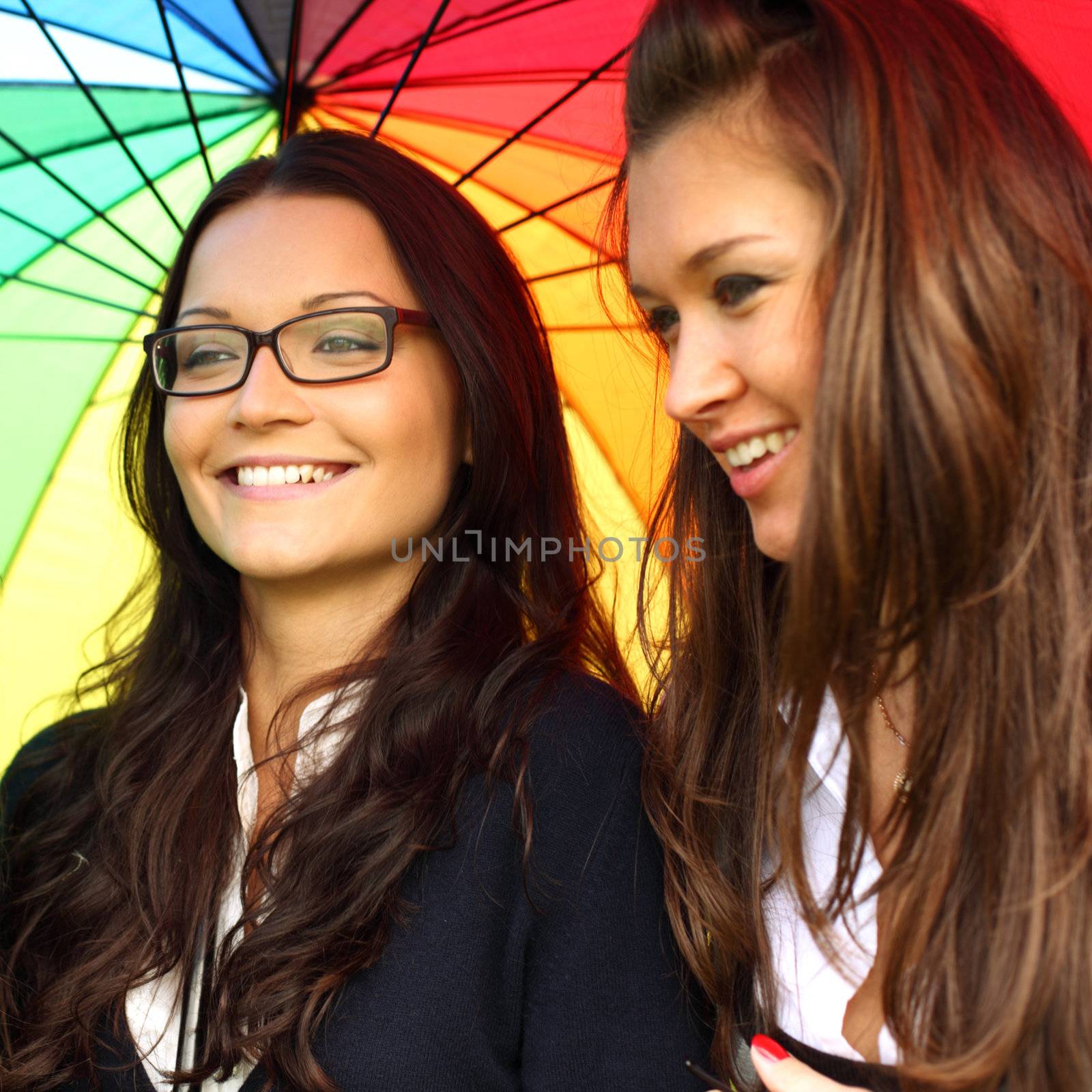 smiling girlfriends under umbrella   by Yellowj