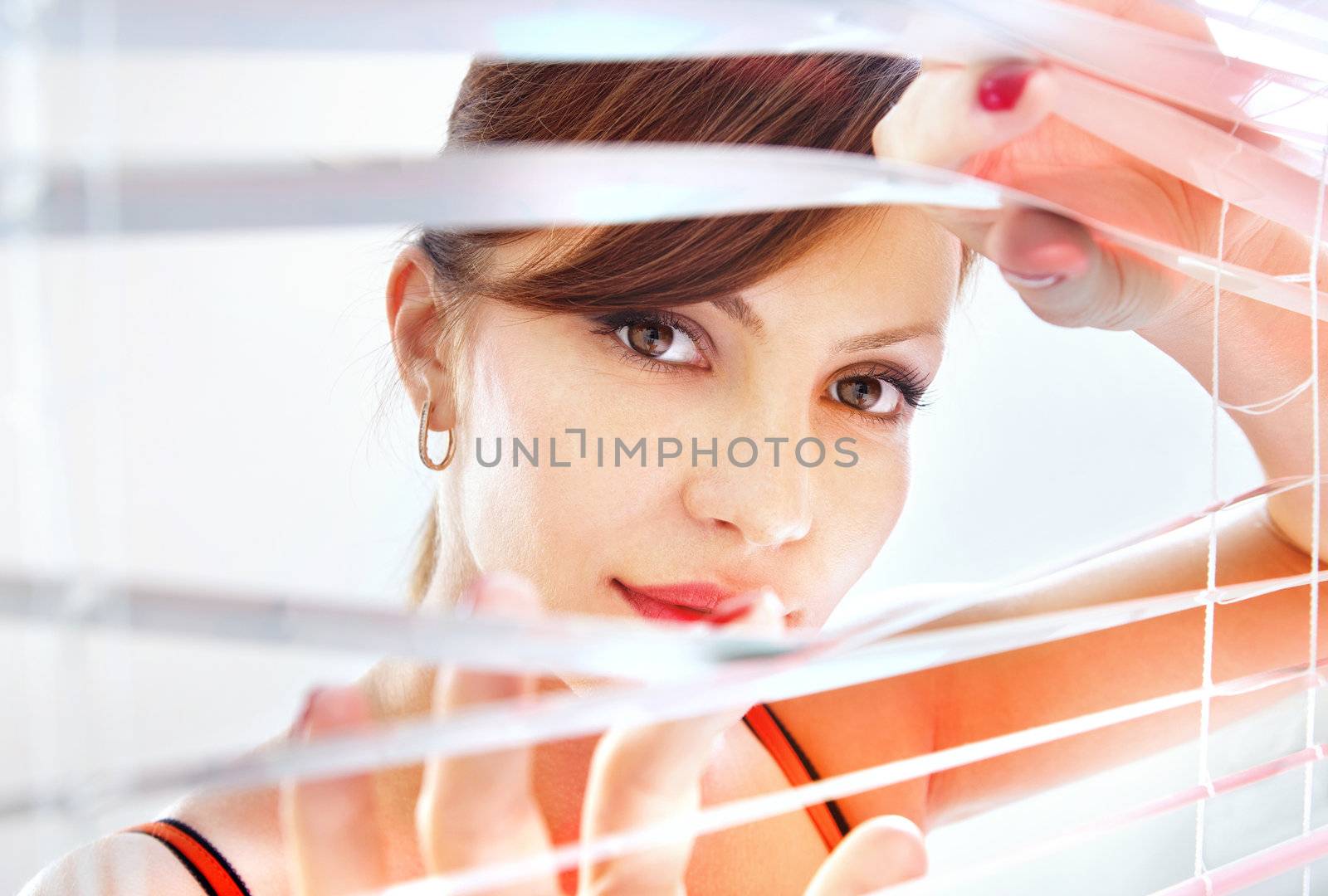 woman looks through jalousie by ssuaphoto