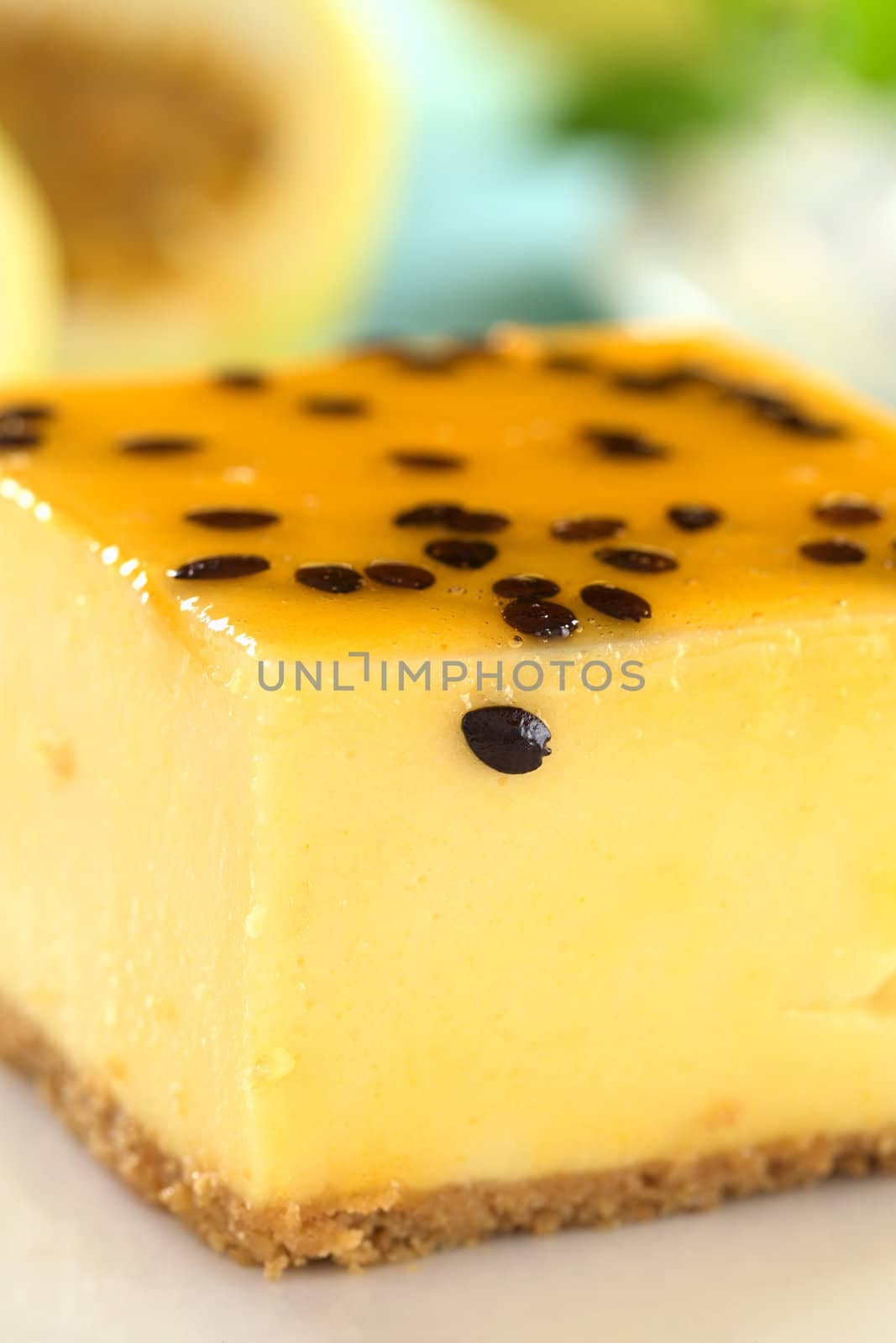 Fresh passion fruit cheesecake dessert on plate (Very Shallow Depth of Field, Focus on the seed on the front of the cake)