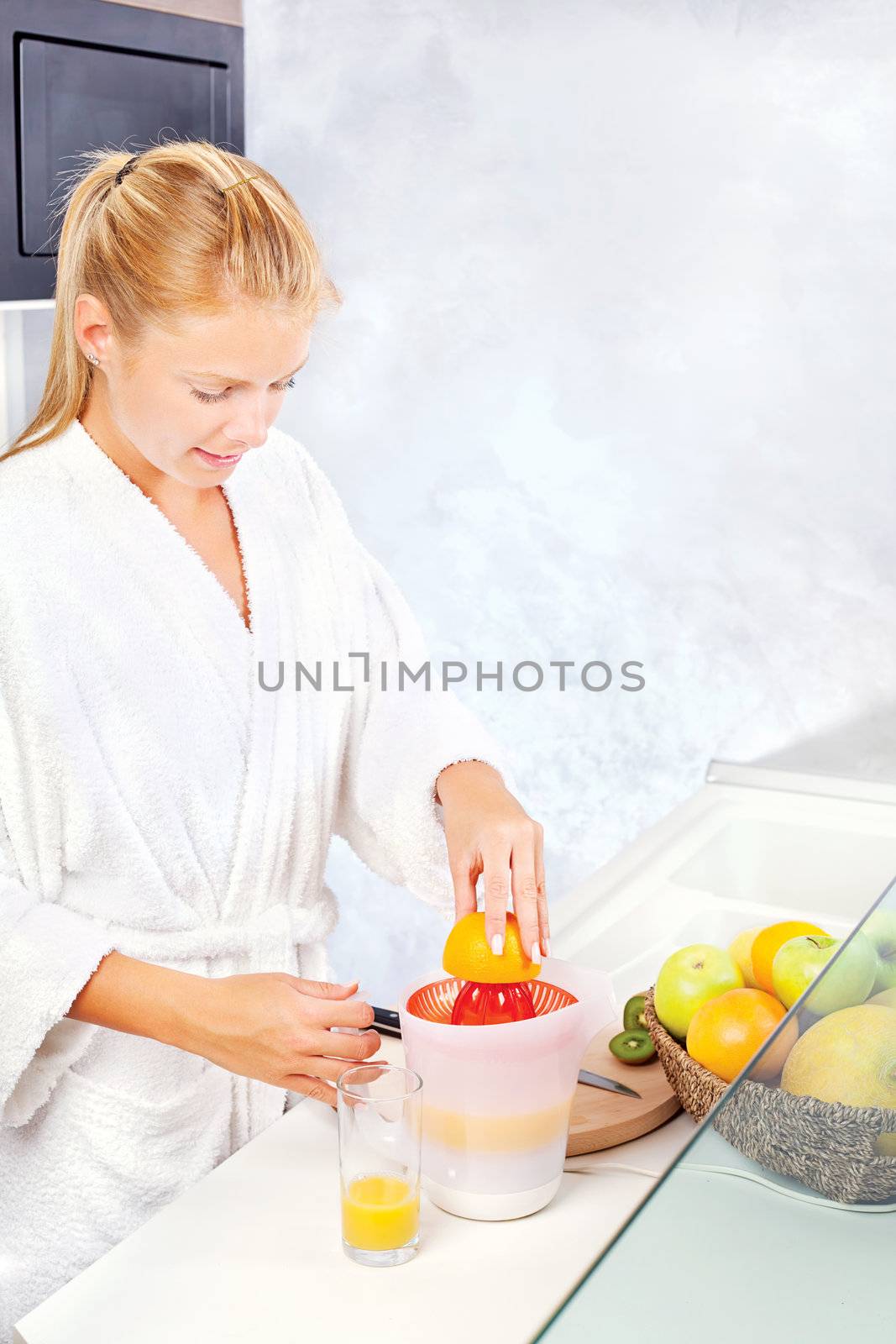 pretty woman making morning juice in kitchen