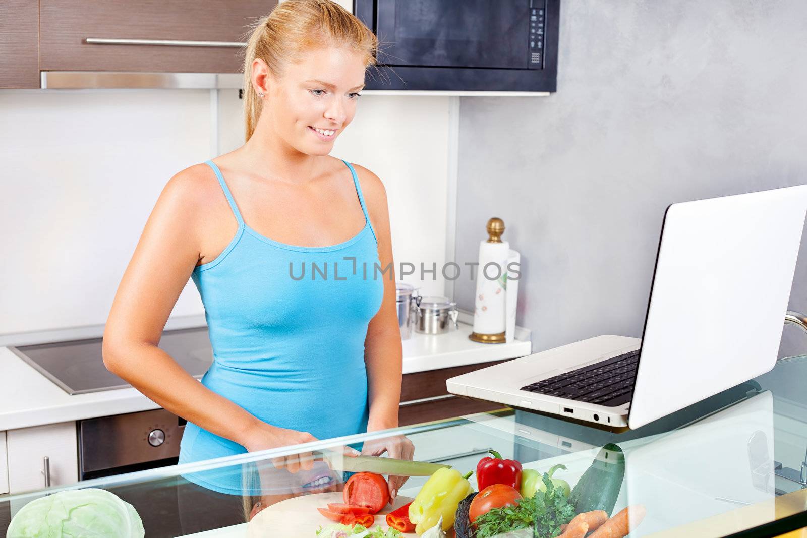 woman in kitchen with laptop by imarin