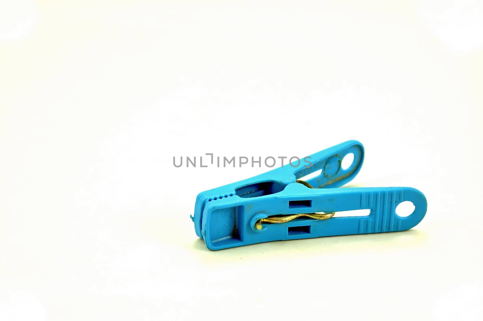 Single blue clothespeg on a white background