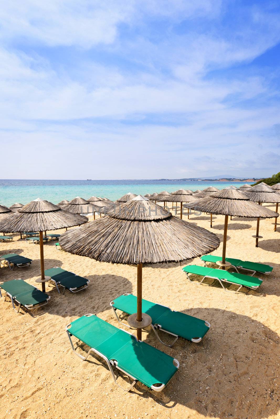 Beach umbrellas on sandy resort coast in Greece
