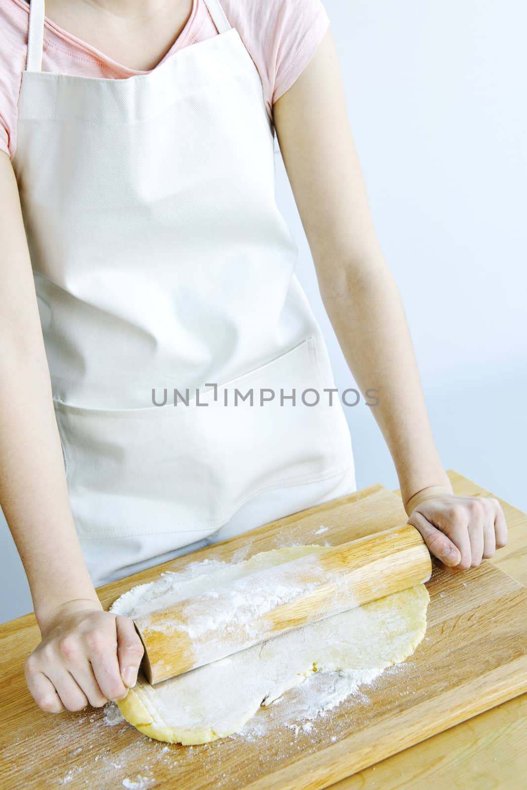 Spreading out cookie dough with wooden rolling pin