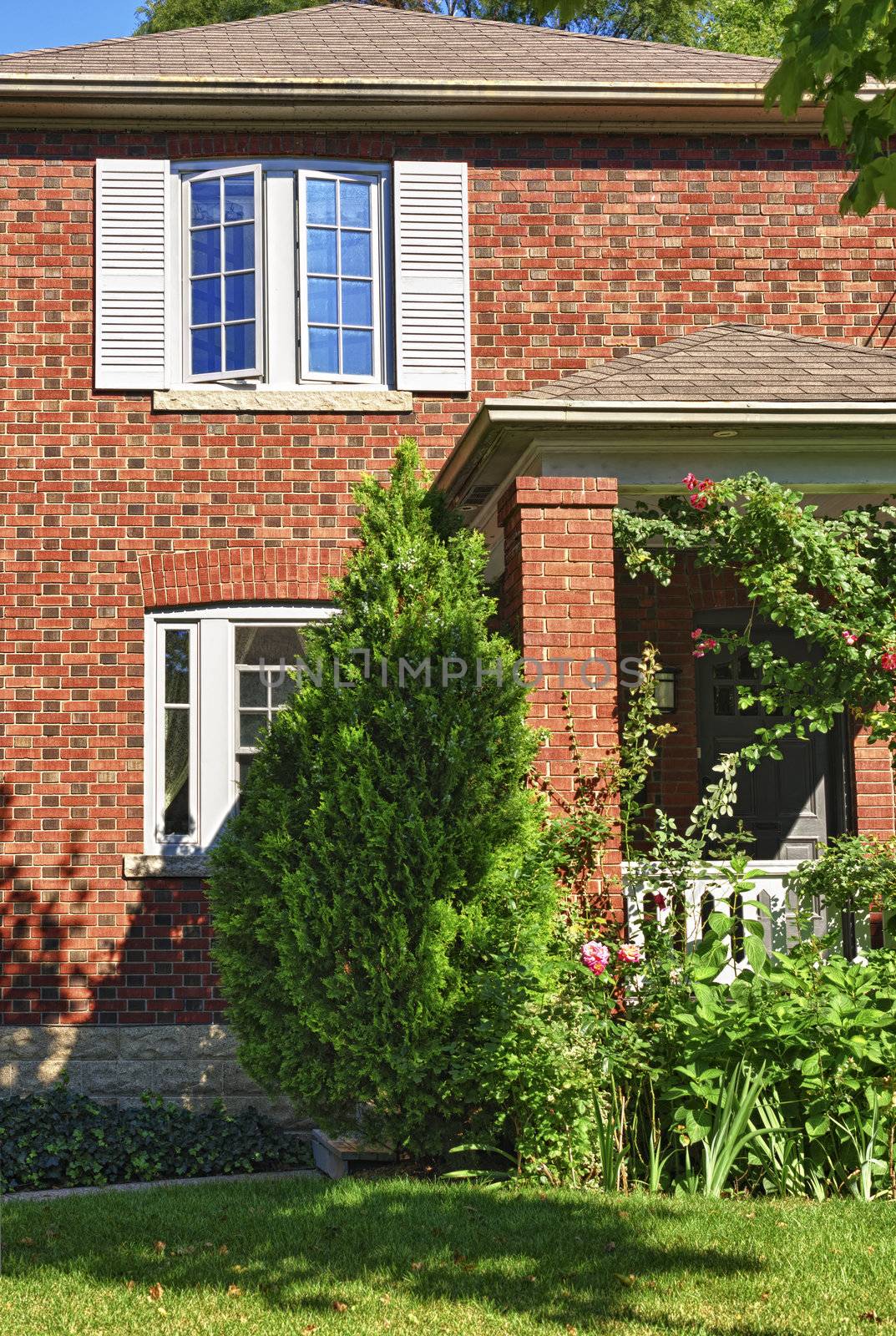 City home in red brick exterior with garden