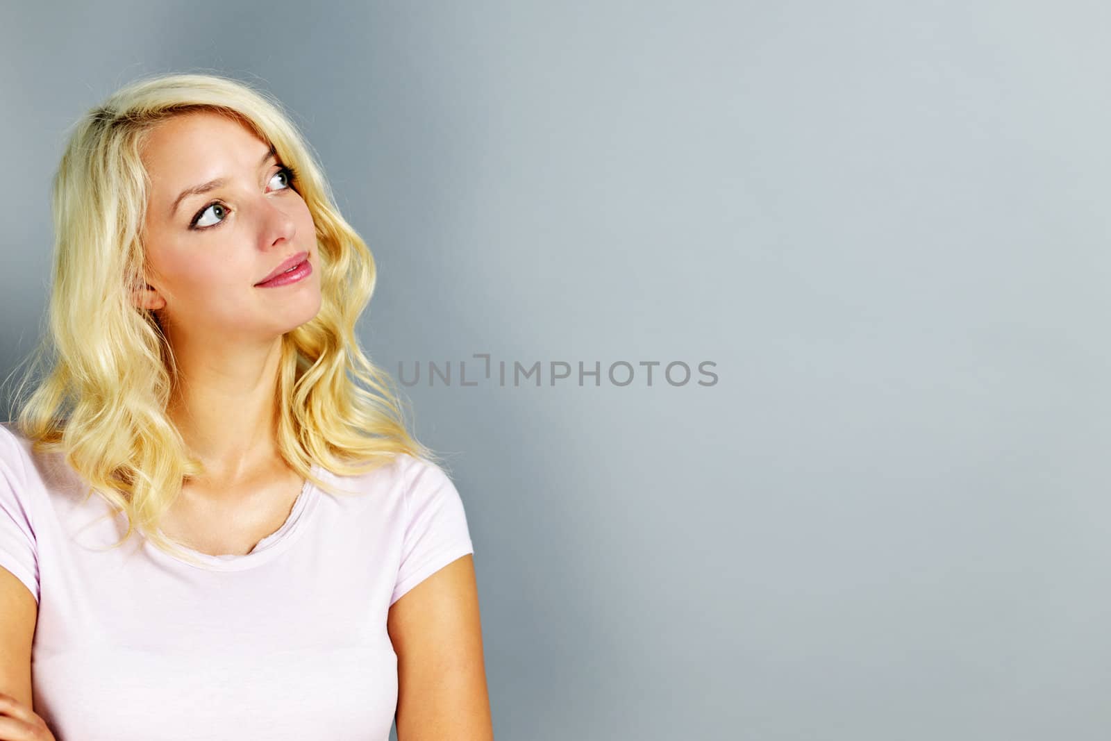 Portrait of young blonde caucasian woman looking to the side and up