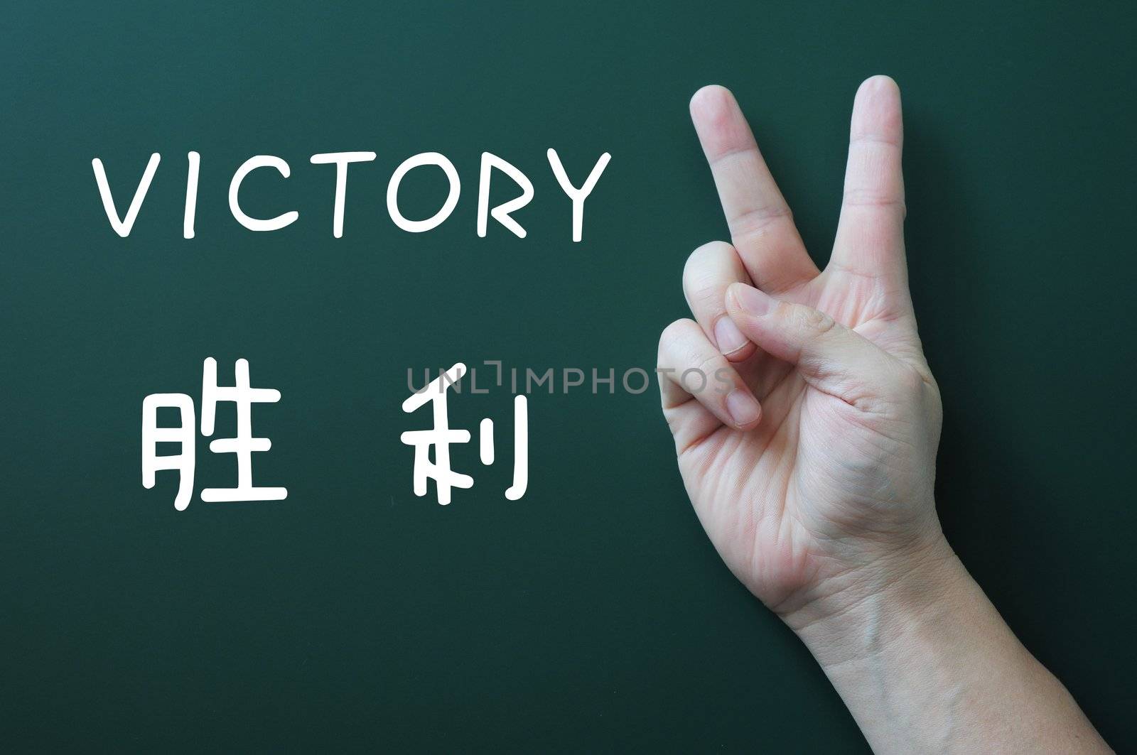 Victory gesture on a blackboard background, with the word victory written in both English and Chinese