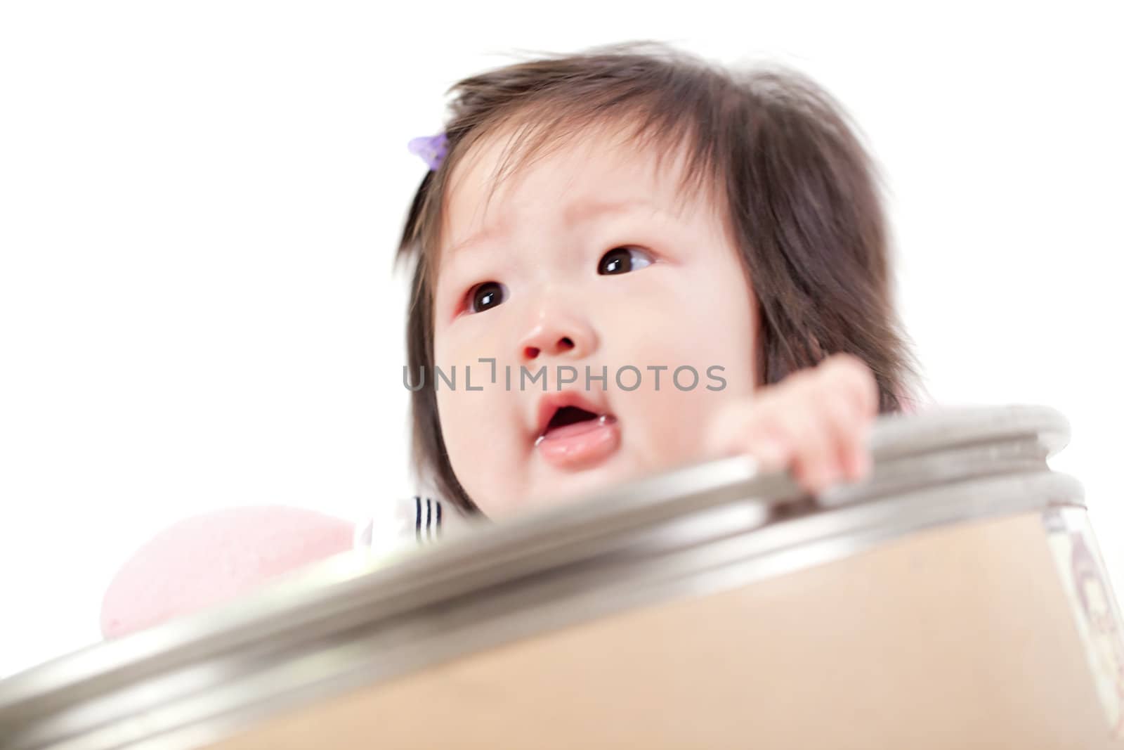 six month baby infant clambers on white surface (selective focus)