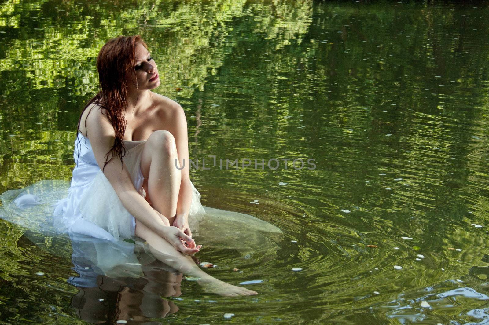 A beautiful bride sitting in water