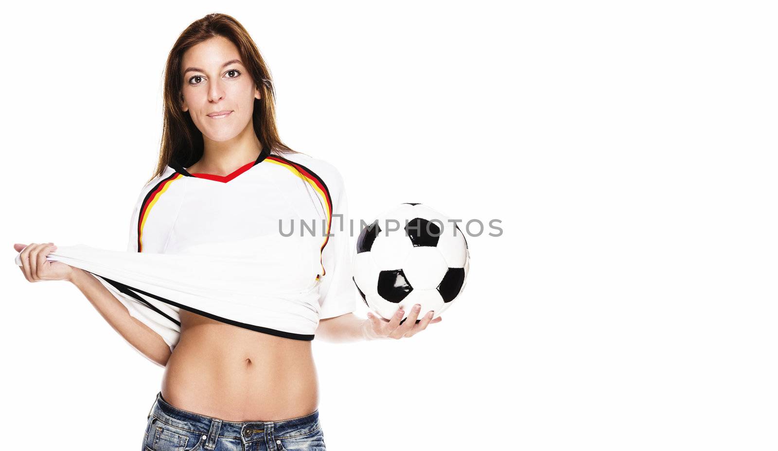 young beautiful woman holding soccer ball pulling on her football shirt on white background