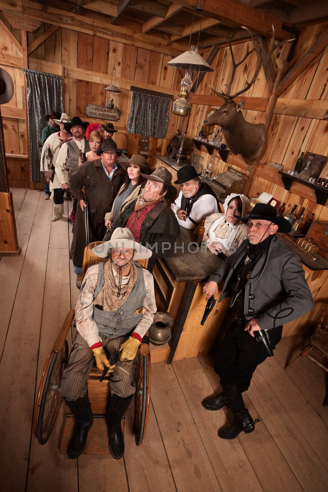 Relaxed customers in old west tavern with weapons at their sides