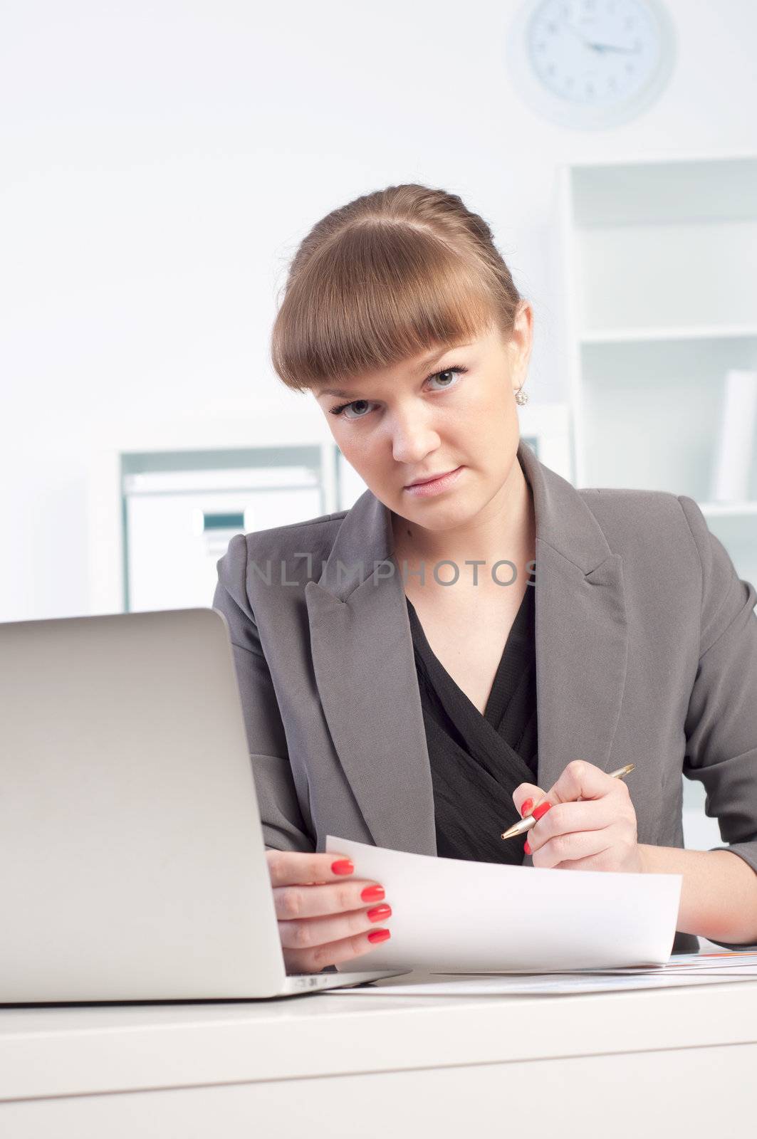 portrait of a beautiful young woman who works at a laptop in the office