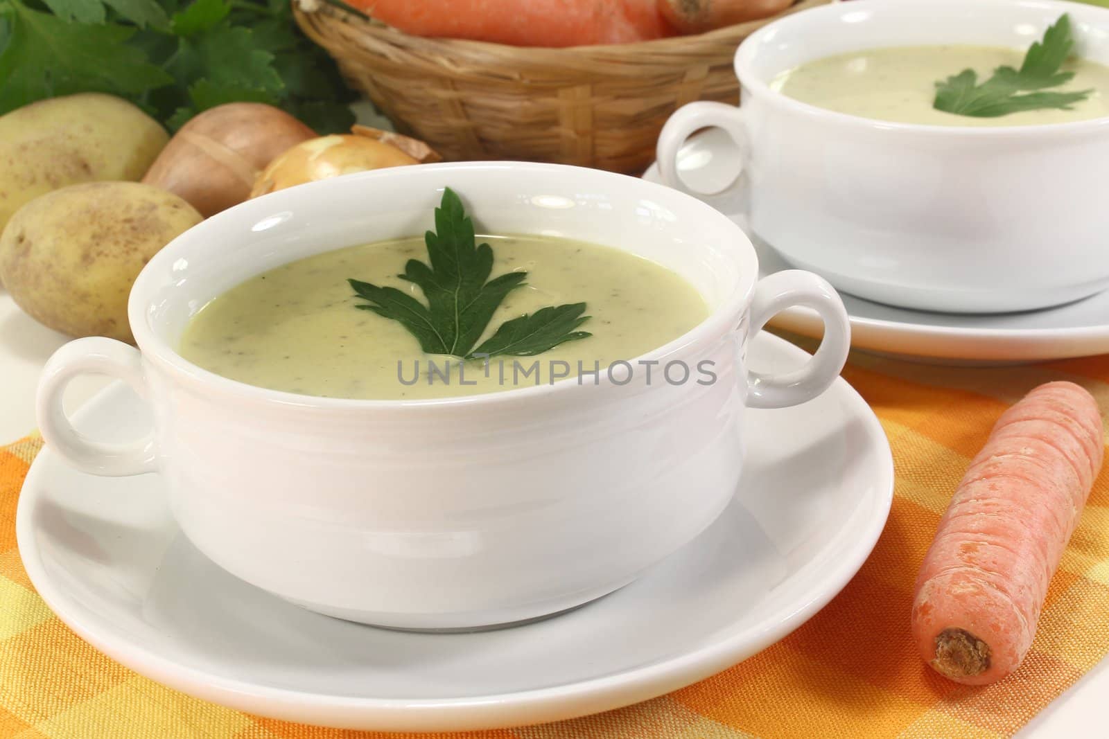 two cups of vegetable creme soup with parsley