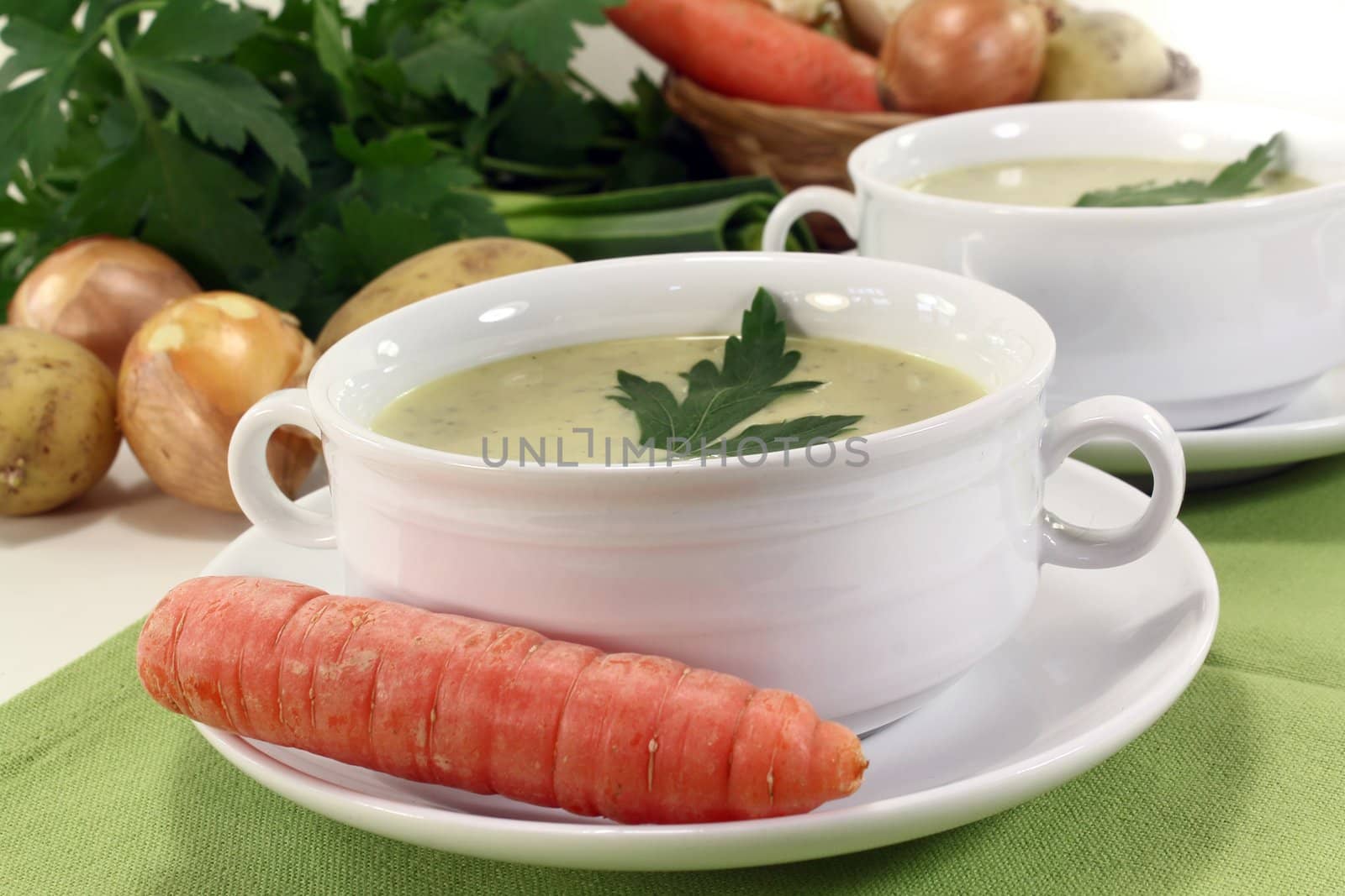 two cups of vegetable creme soup with parsley