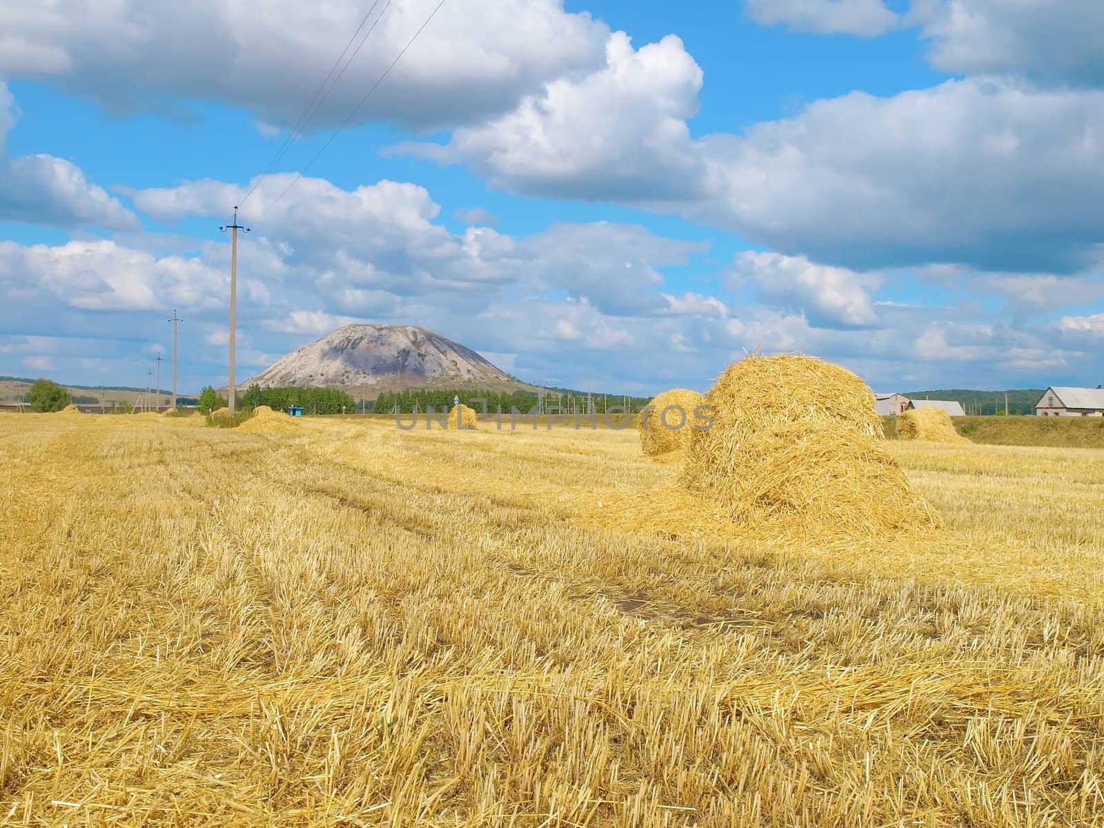 Haystack with high hill on background.