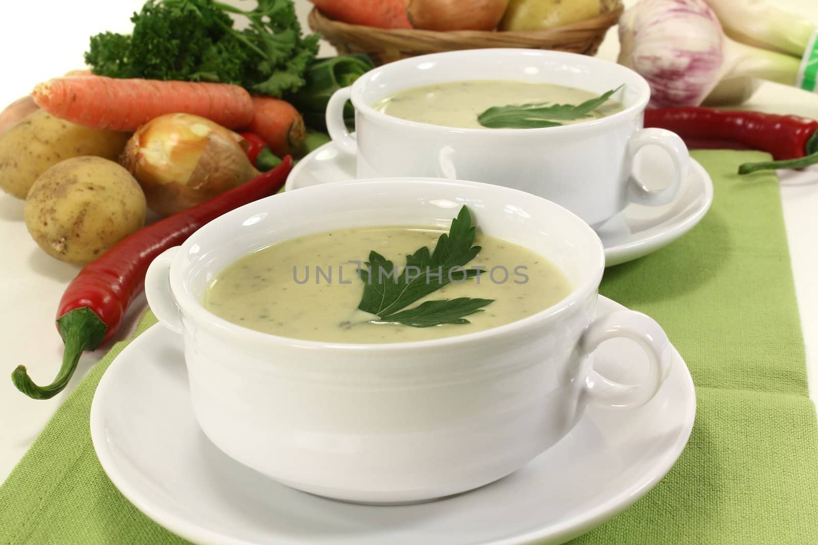 two cups of vegetable creme soup with parsley