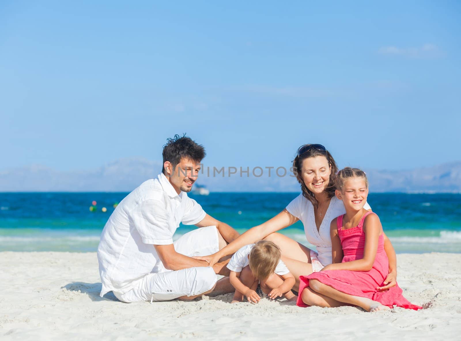 Family of four having fun on tropical beach