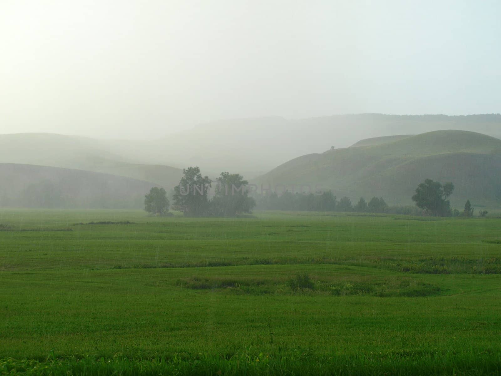 Summer landscape with mountains and rain.