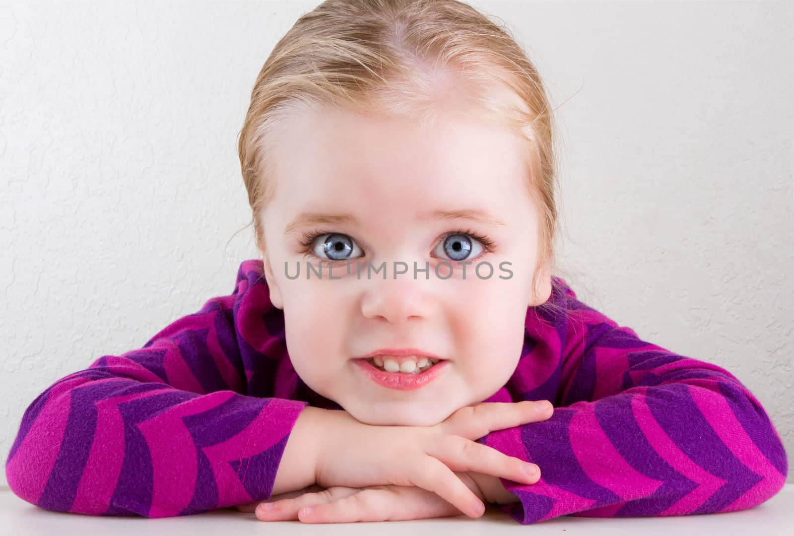 Single child with big bright eyes smiling straight at the camera