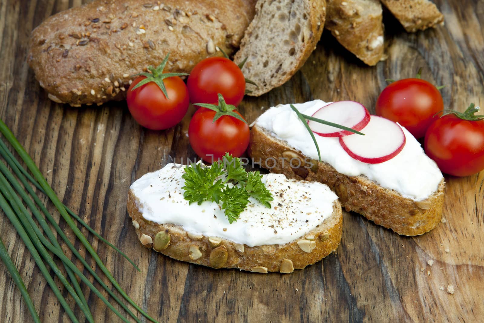 fresh bread with herb curd dinner on wooden background