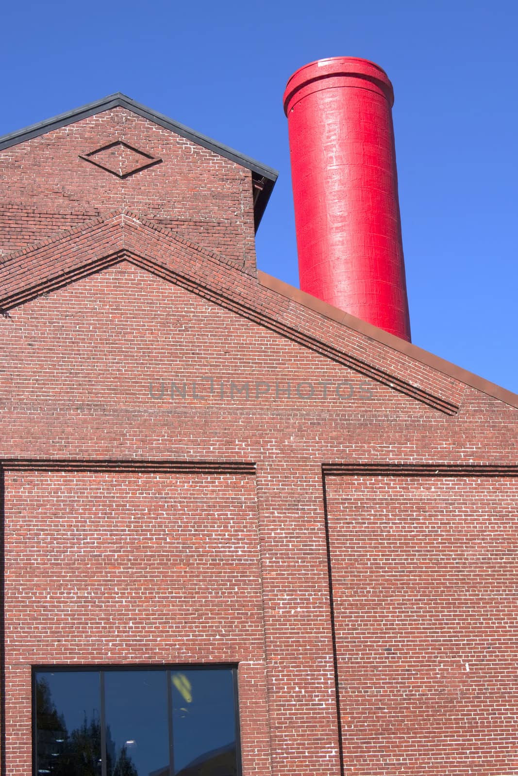 Red chimney a window and brick building.