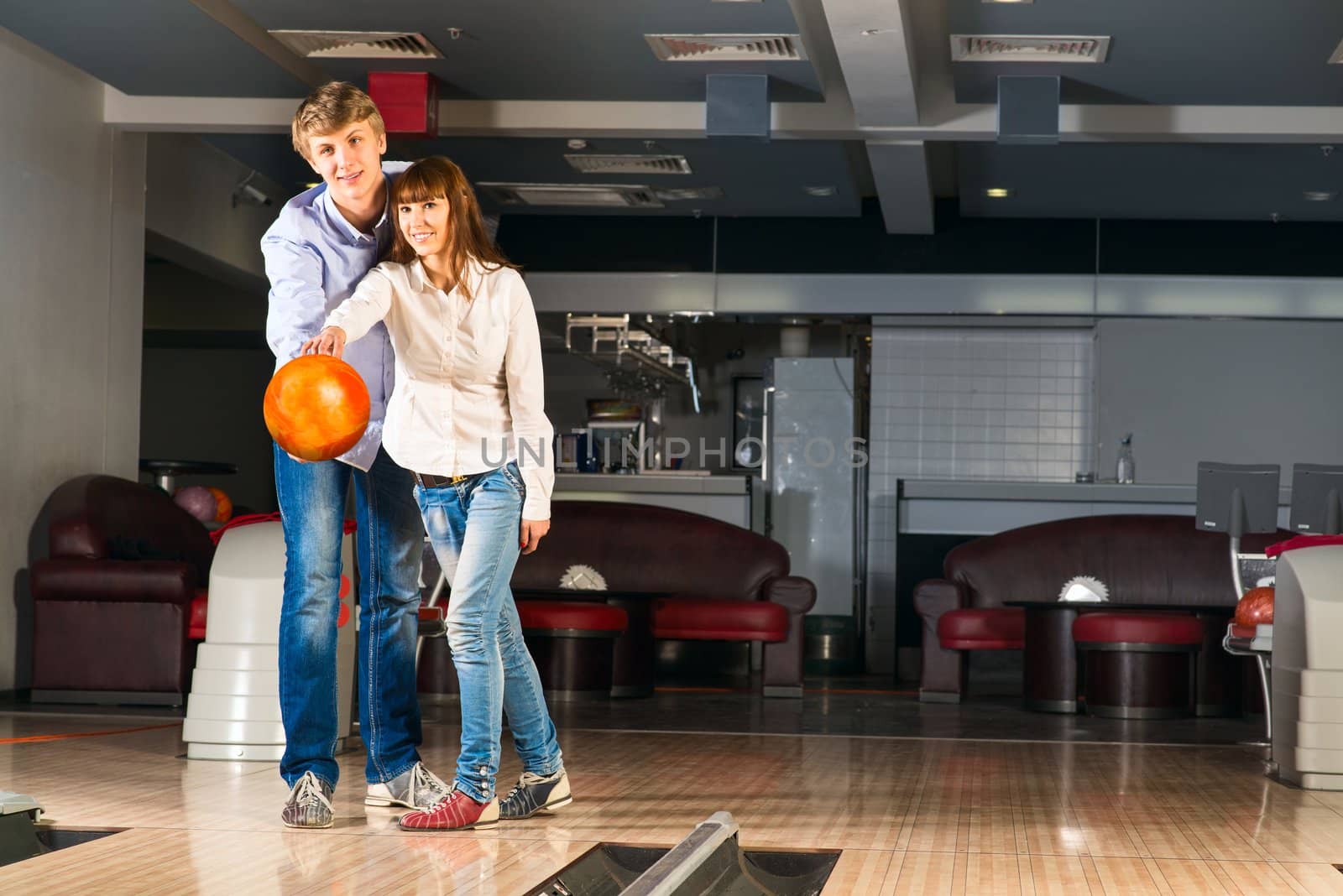 guy hugs her friendgirl, playing together in bowling