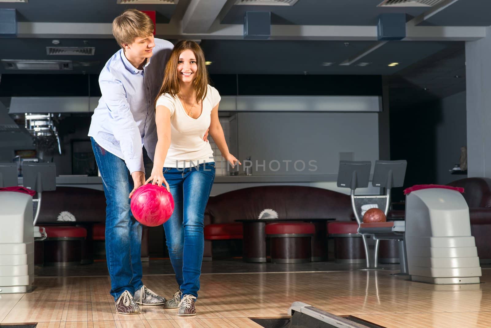 guy hugs her friendgirl, playing together in bowling