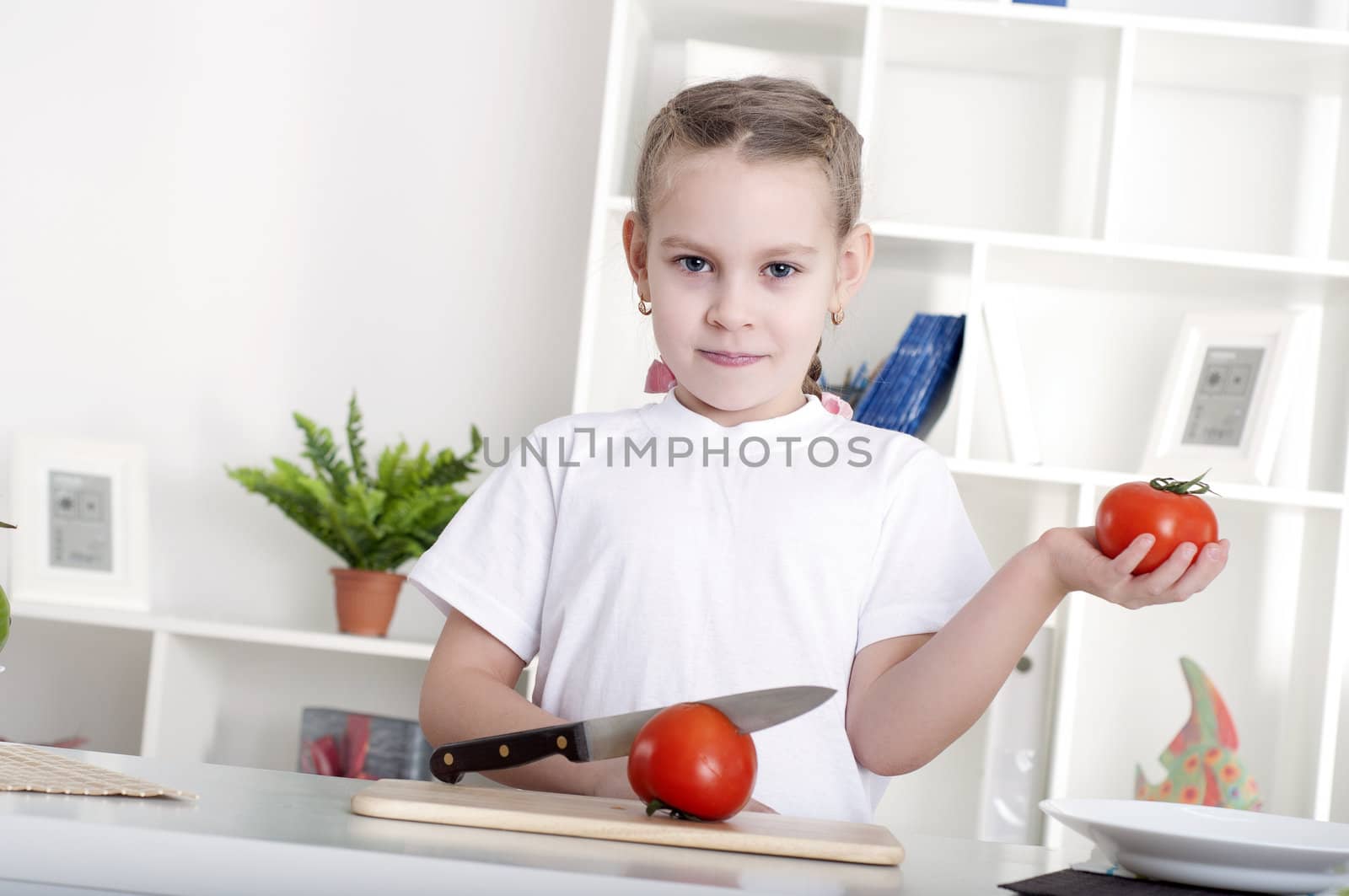 beautiful girl in the kitchen cooking vegetables