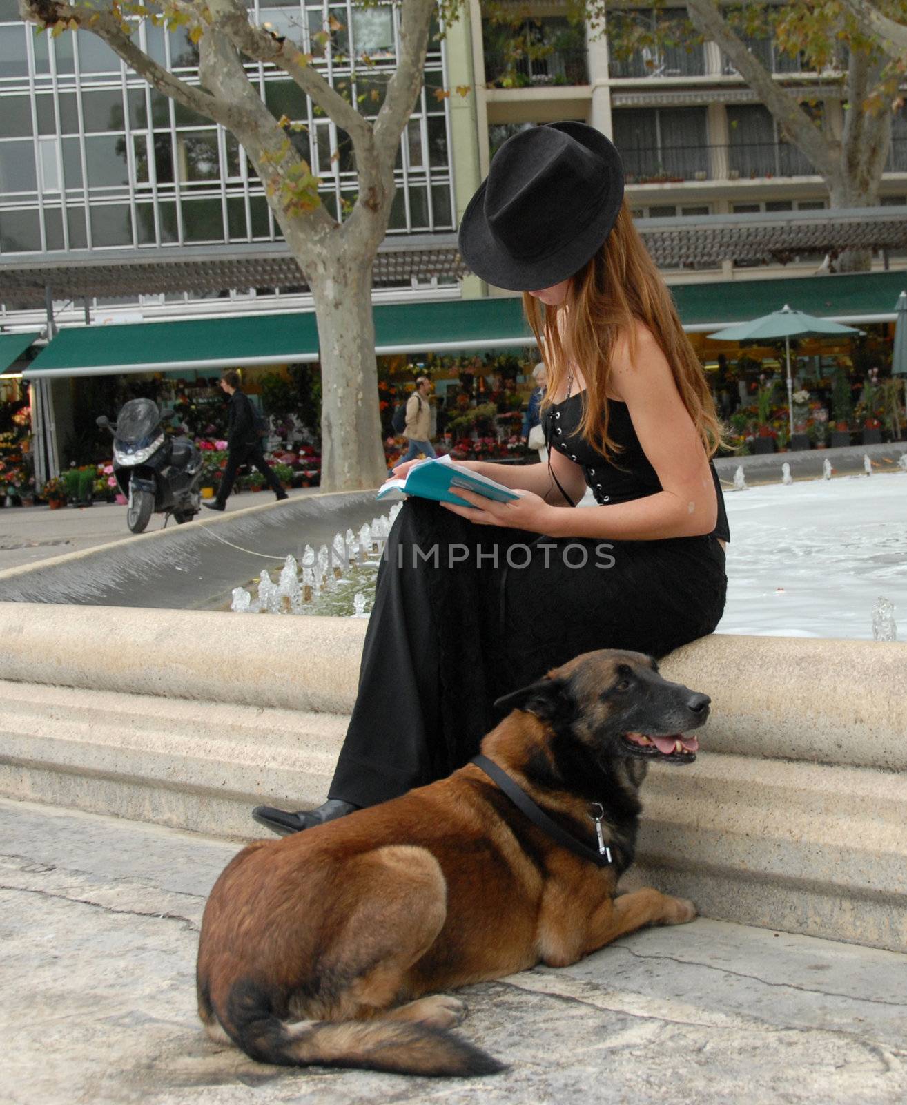 beautiful teenager reading her book with her dog
