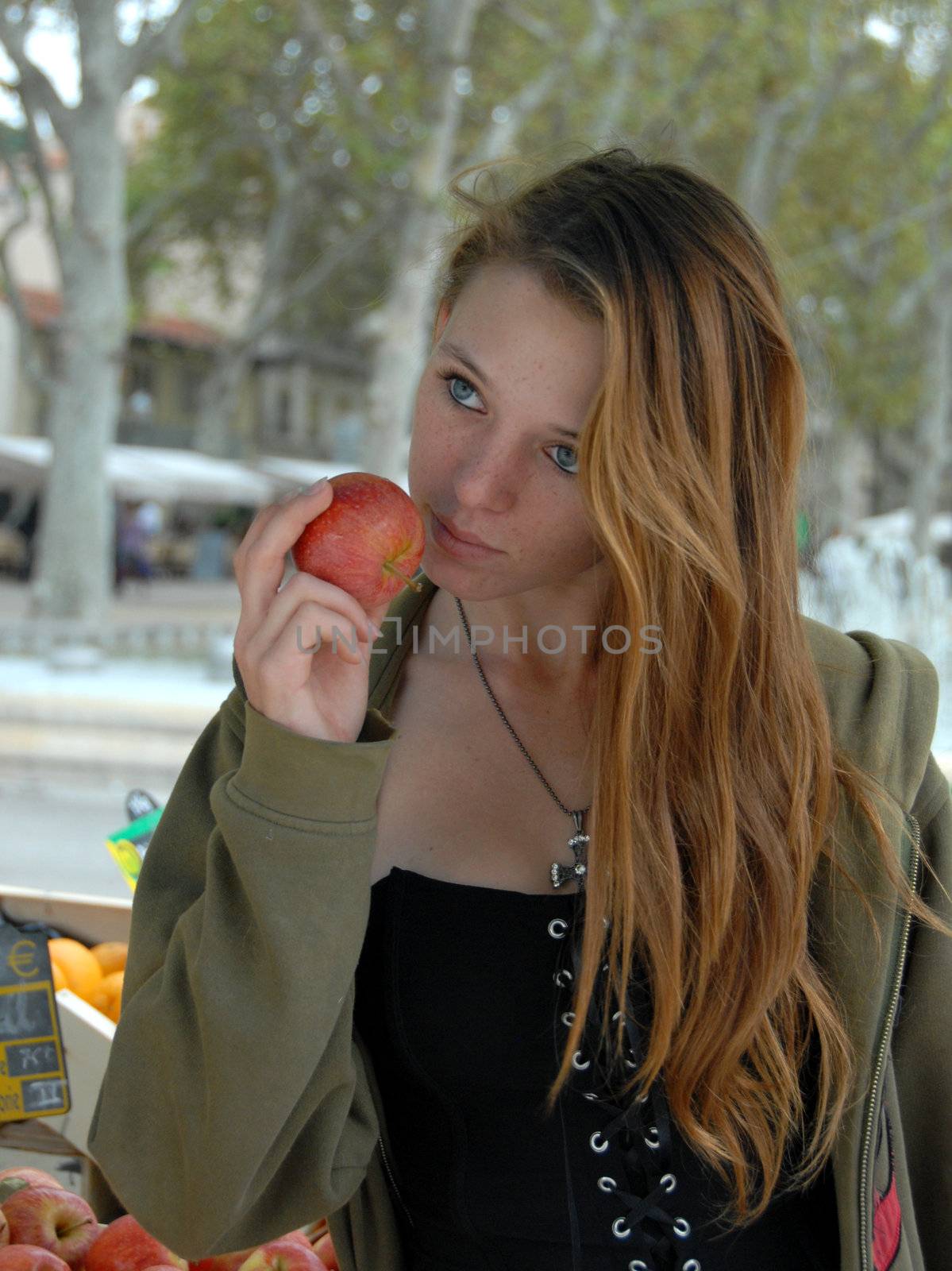 young teen in a market in montpellier for buy red apple

