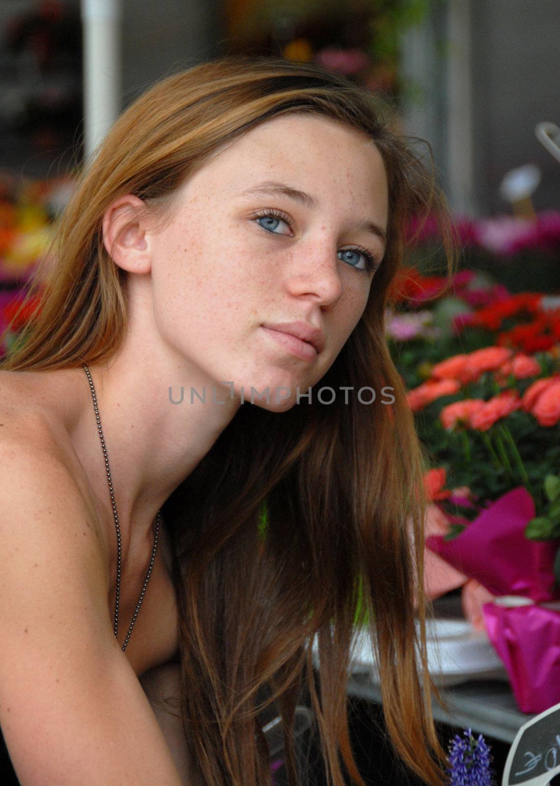 portrait of a beautiful teenager watching a pot of plant
