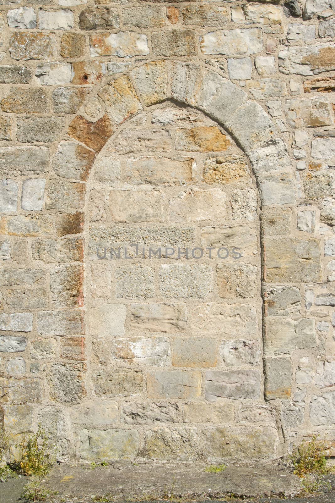 An historic doorway, entrance, filled in with matching stonework.