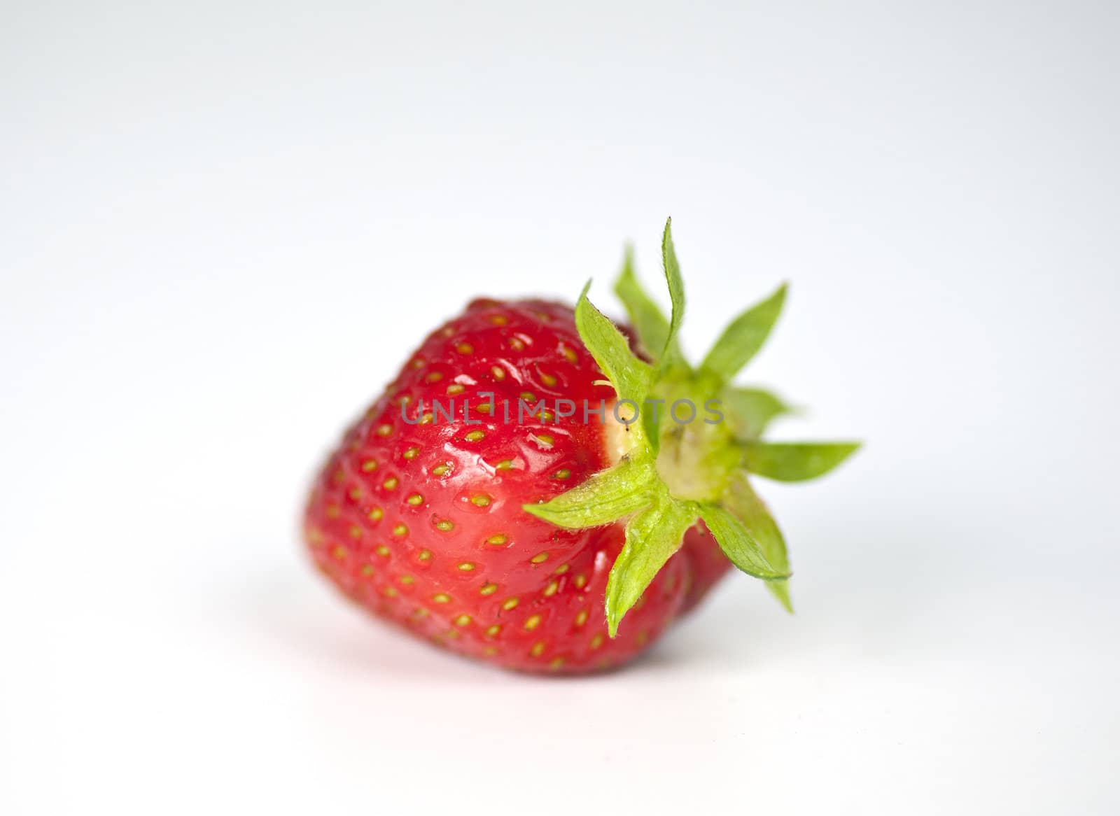 Closeup of a single strawberry on a white background