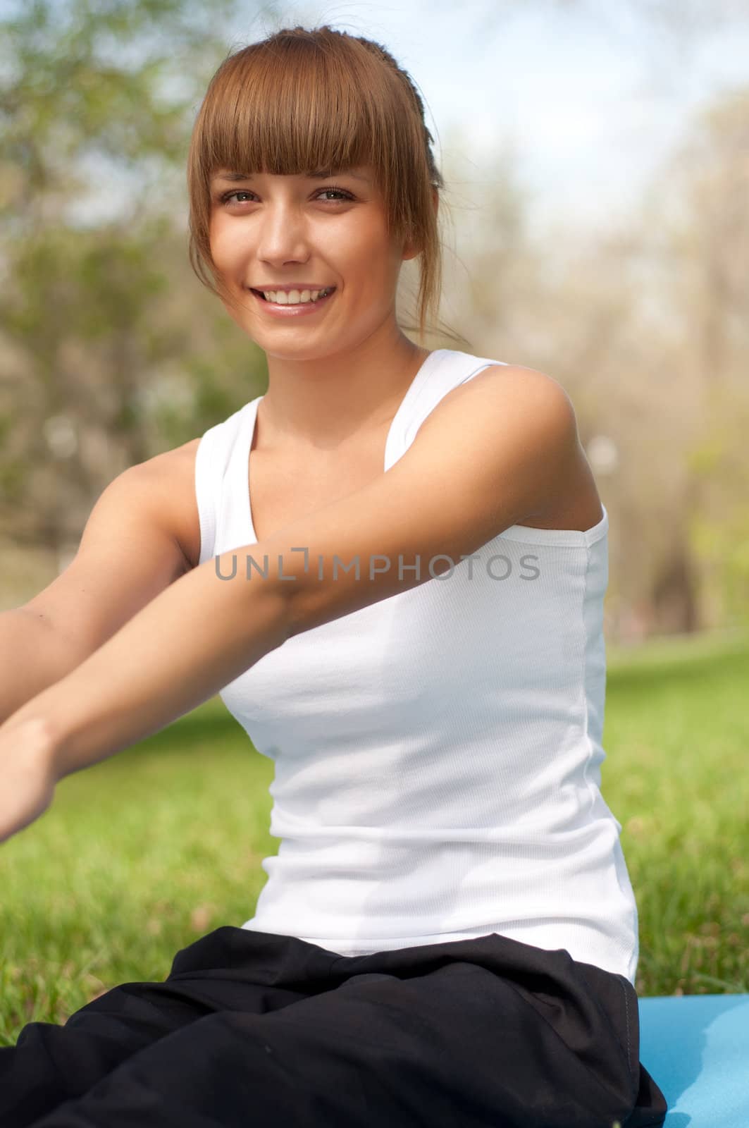 beautiful young woman performs a sport exercises in the park