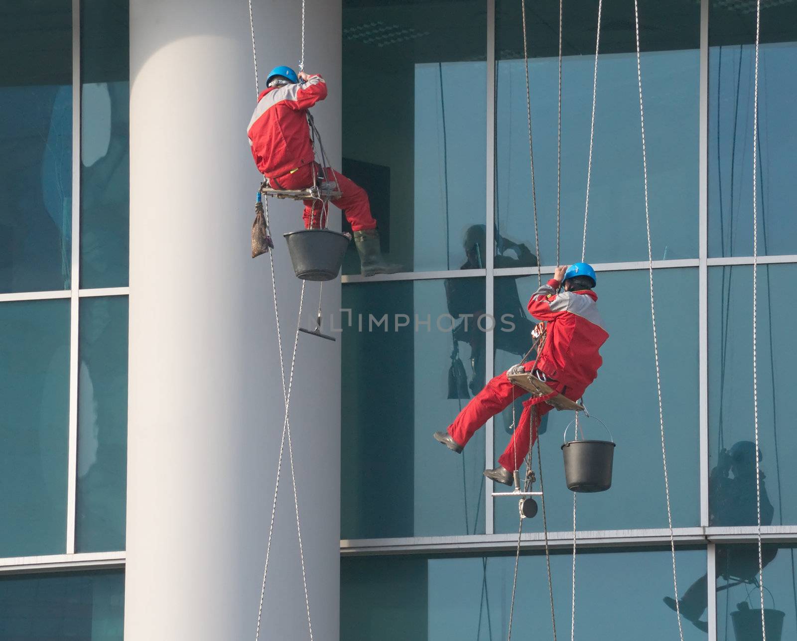 Climbers - window cleaners perform the work at wall of an office building