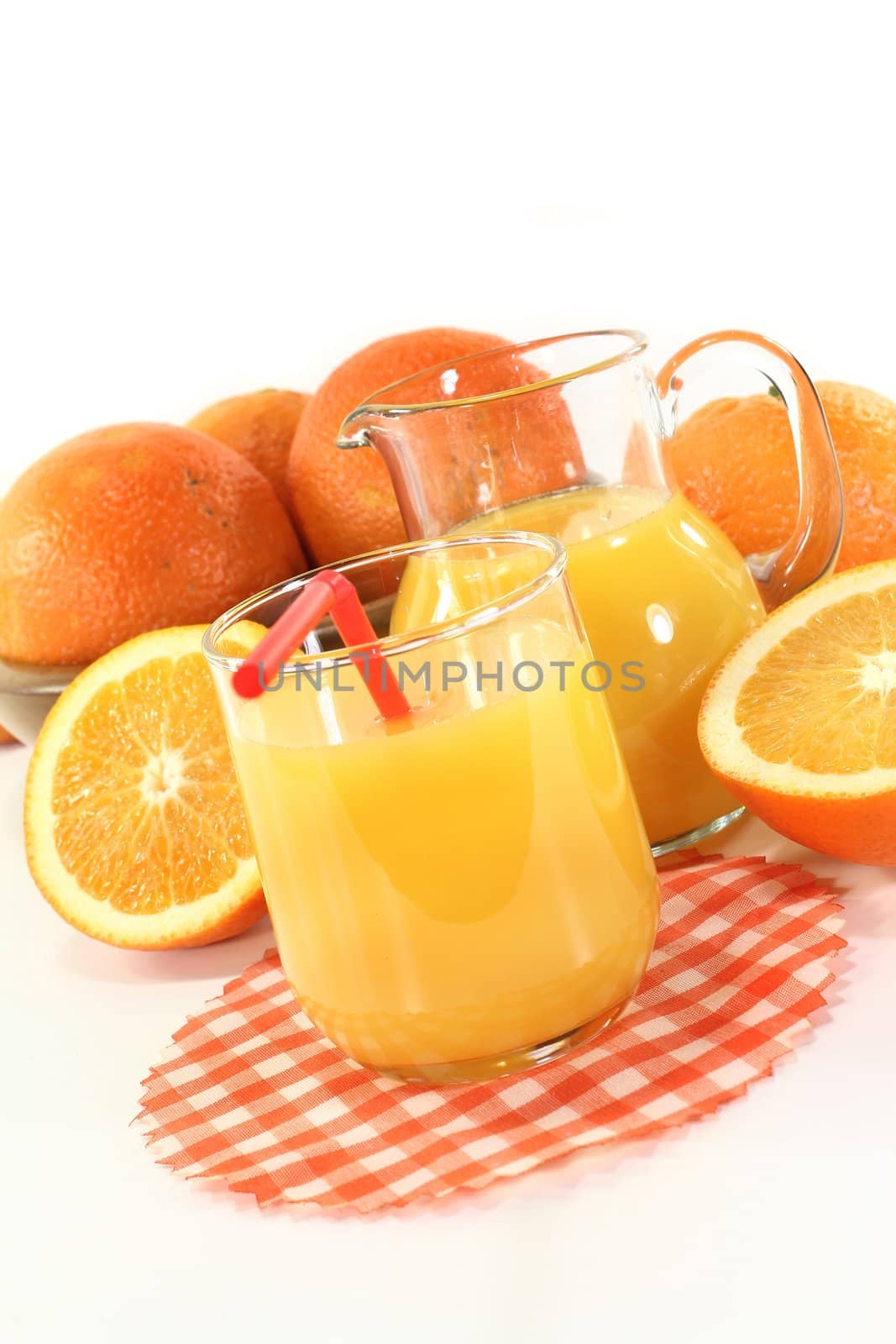 a glass of orange juice and fresh oranges