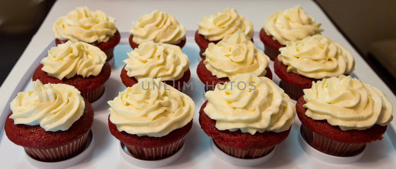 Tray of red velvet cupcakes with buttercream icing.