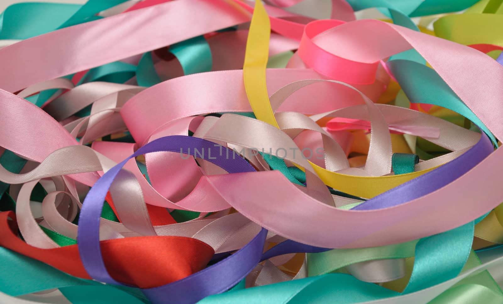 Multi-colored satin ribbons in a chaotic manner closeup