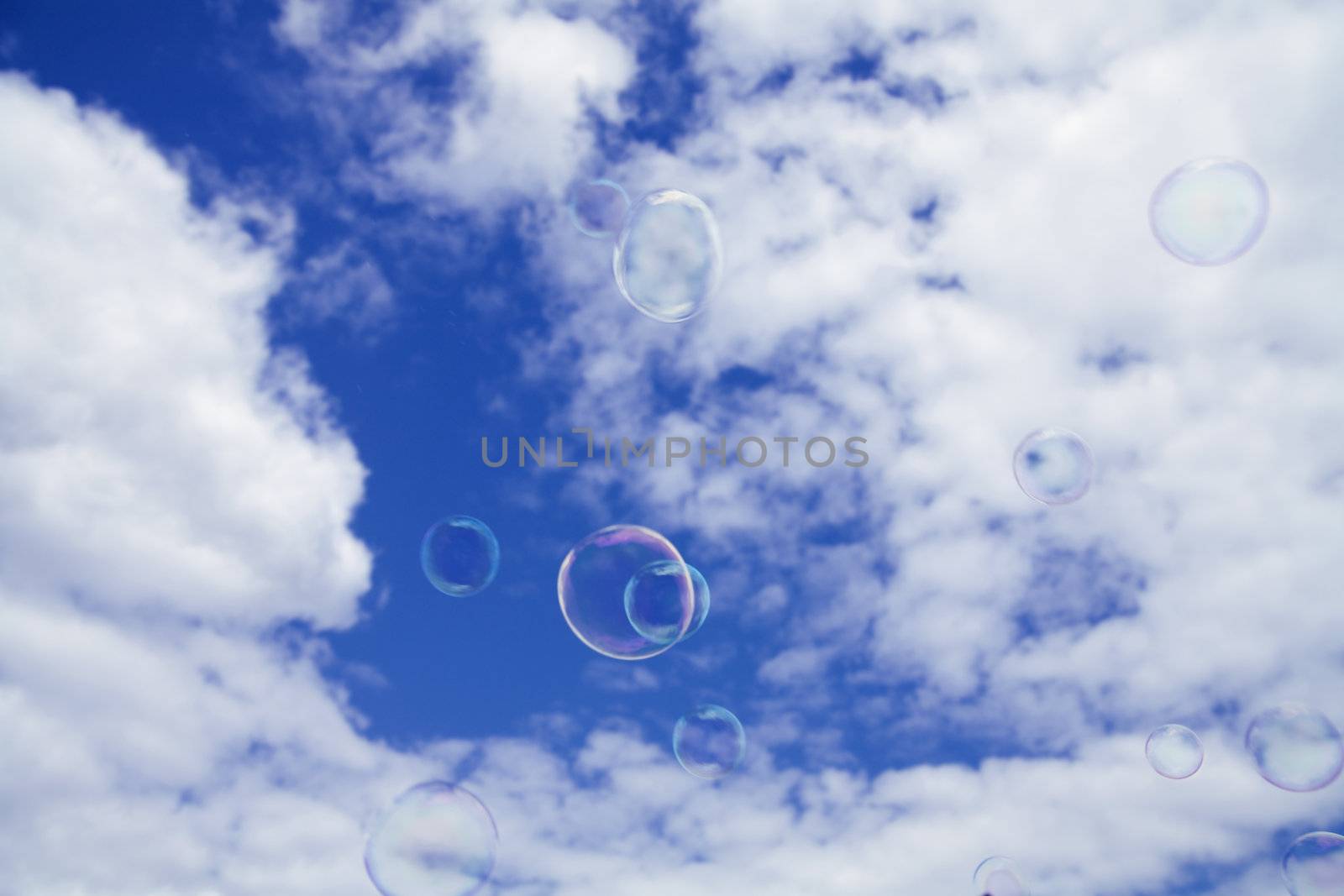 great number of transparent bubbles on a cloudy sky background
