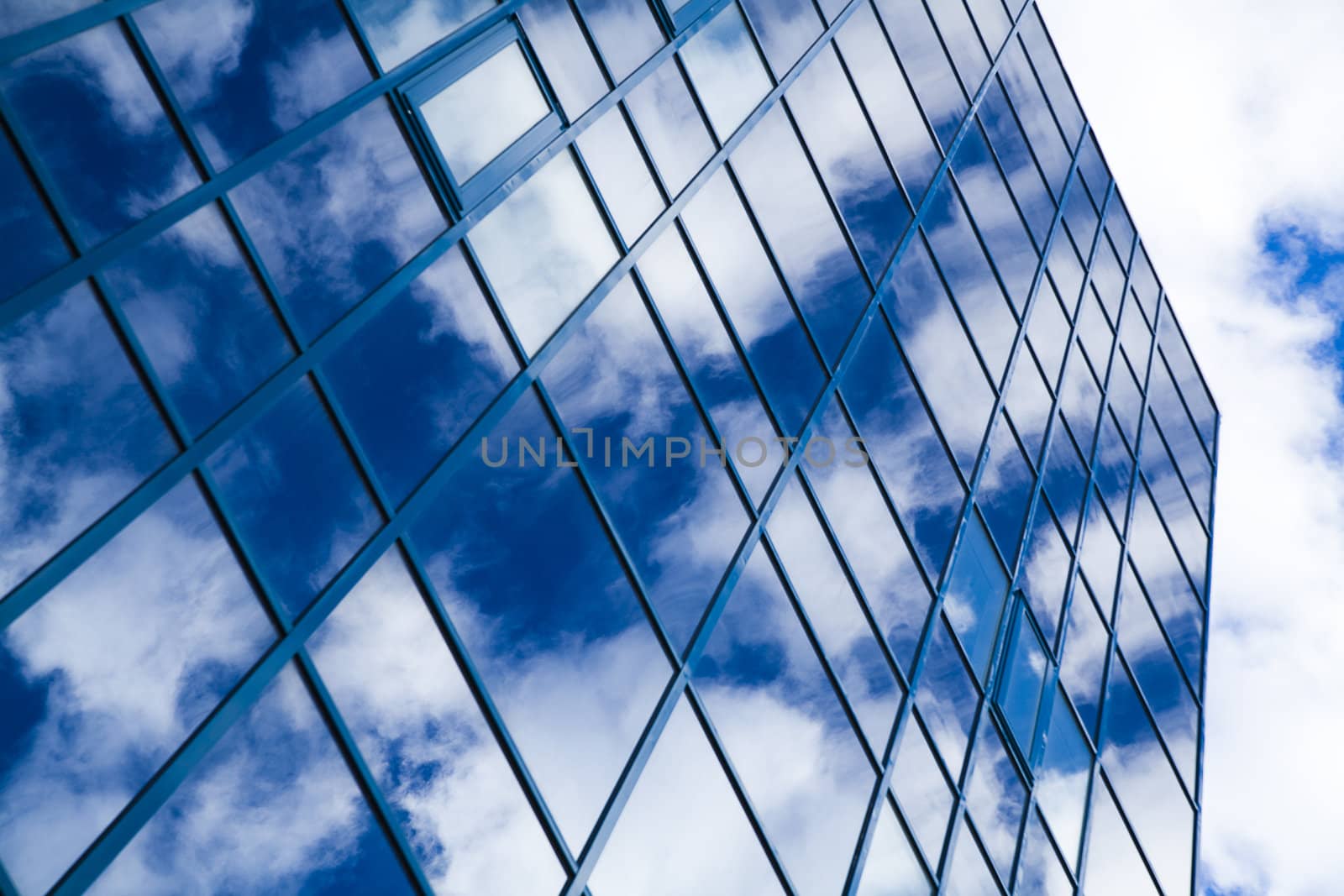 windows of skyscraper with reflections on a background cloudy sky