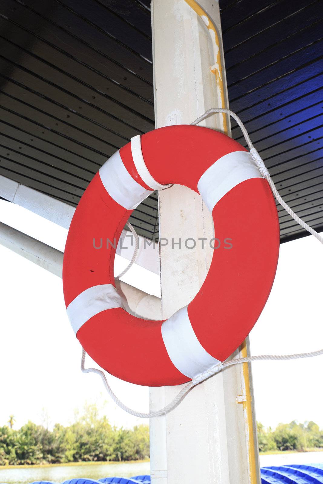 Life ring hang on white pole is on boat.