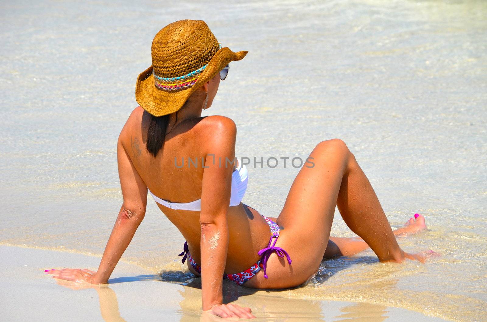 attractive young woman cooling off at the water's edge on a southeast florida beach