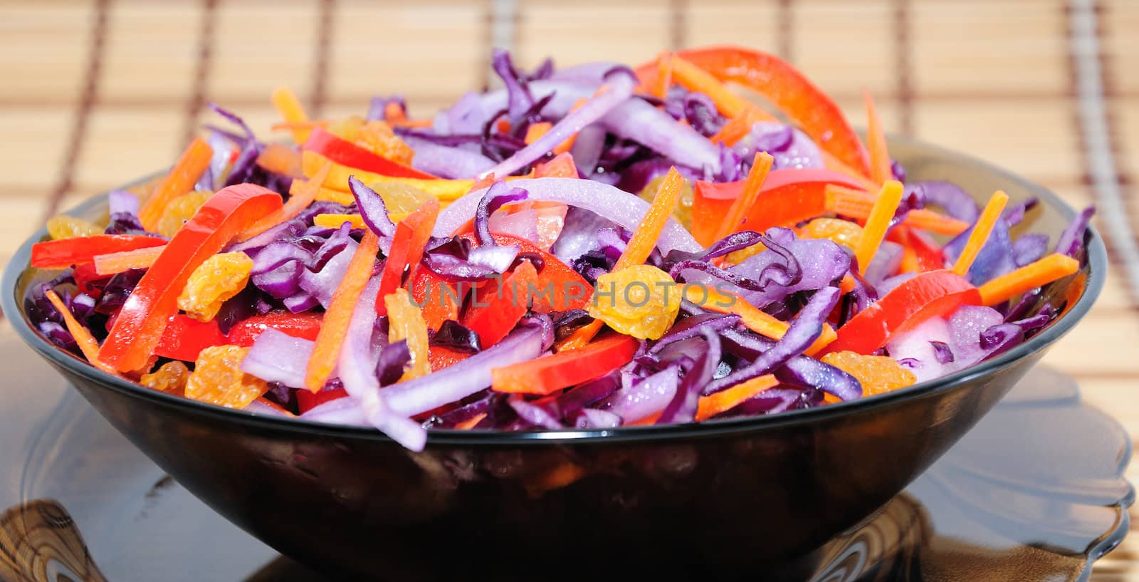 Salad of blue cabbage with carrots, peppers and raisins